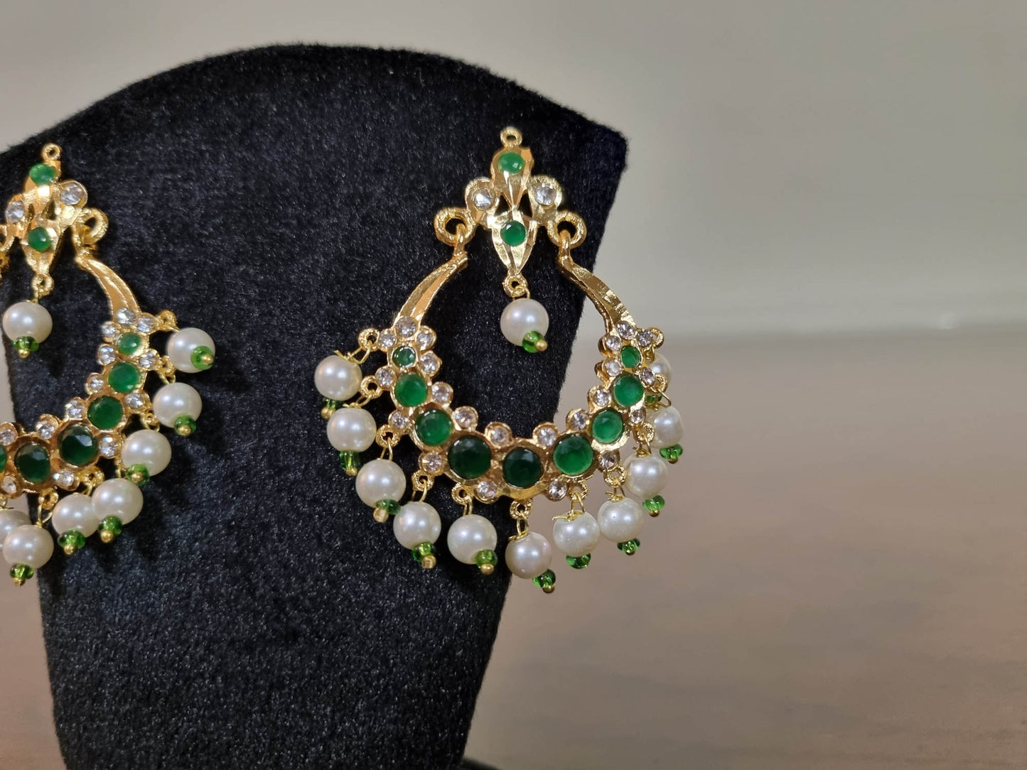 Elegant Zamurd Chandbali Earrings with intricate gold finish and sparkling green emerald-style stones, perfect for festive wear and wedding events