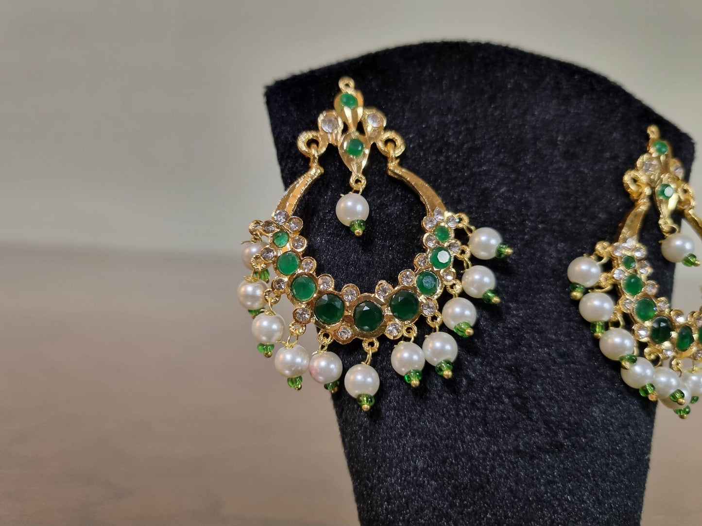 Elegant Zamurd Chandbali Earrings with intricate gold finish and sparkling green emerald-style stones, perfect for festive wear and wedding events